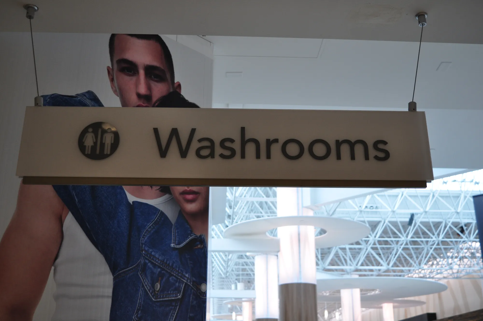 Ceiling-hung Washrooms wayfinding sign in a Vancouver store